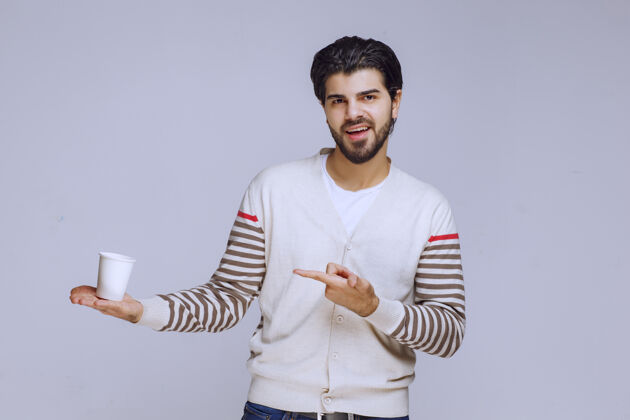 姿势男人指着手里的塑料咖啡杯休闲成人一次性