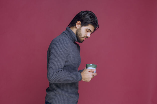 休息一个穿着灰色毛衣的男人手里拿着一个咖啡杯模特休闲成人