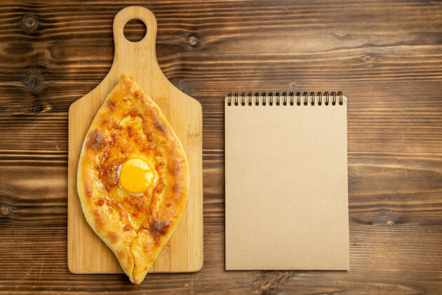 一餐俯瞰美味的鸡蛋面包烤在棕色的木制桌子上面包包烤早餐鸡蛋胡椒粉烘焙蛋