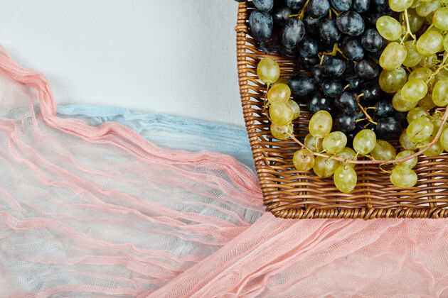 潮湿一簇混合的葡萄放在篮子里 蓝色和粉色的桌布高质量的照片农业健康一串