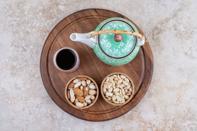 木头有茶壶和坚果的木板腰果食物杯子