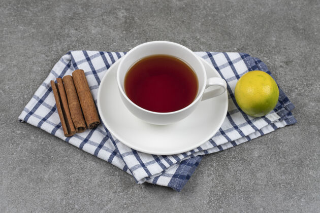 柠檬一杯茶 肉桂棒和柠檬放在大理石表面杯子桌布健康