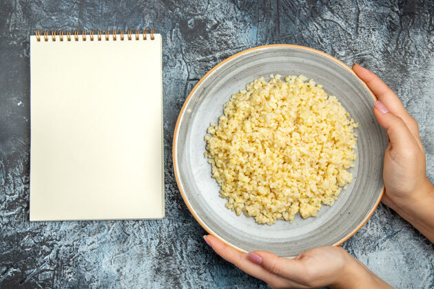 笔记本煮熟的珍珠大麦顶视图内板与记事本上轻表面米饭灯食物