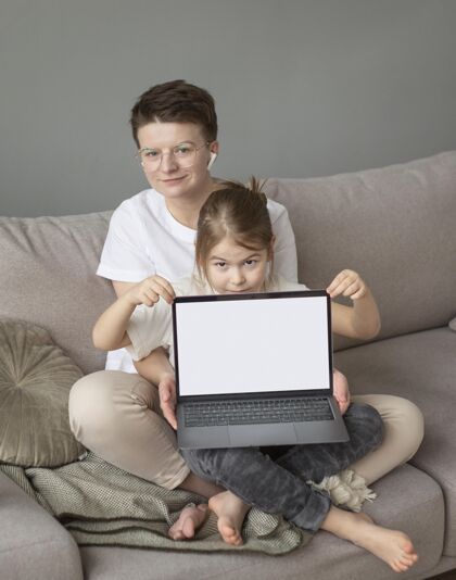 父母全拍家长和孩子在沙发上用笔记本电脑房子童年远程工作