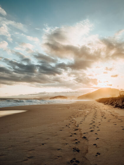 海景在里约热内卢海滩日落时沙滩上的脚印美景天空日落水