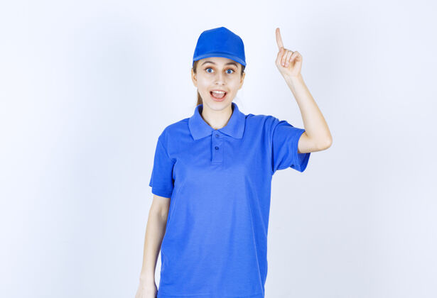 员工穿蓝色制服的女孩指着上面的东西姿势年轻人成人