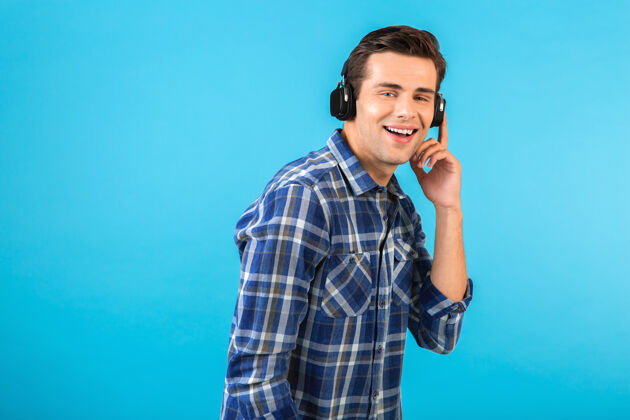 时髦时尚帅气的年轻人戴着无线耳机听音乐自信微笑设备