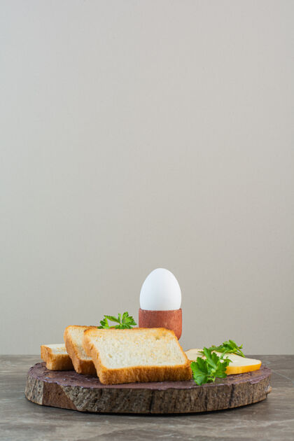 糕点把面包片 奶酪和煮鸡蛋放在一块木板上 放在大理石背景上面包面包面包