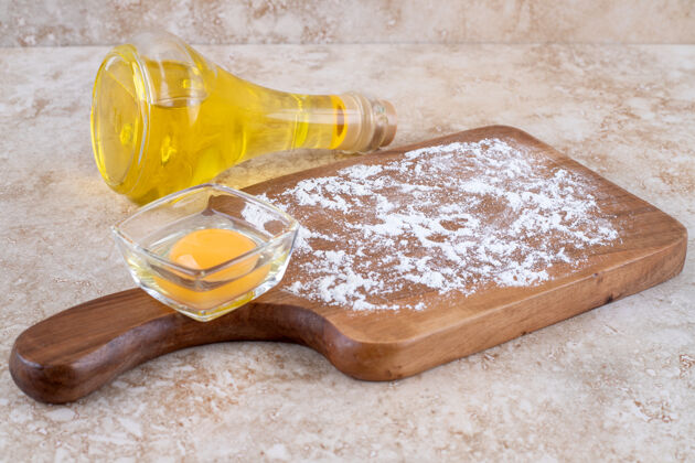 油一块装着生蛋黄的木板和一瓶玻璃油美味的没准备的玻璃