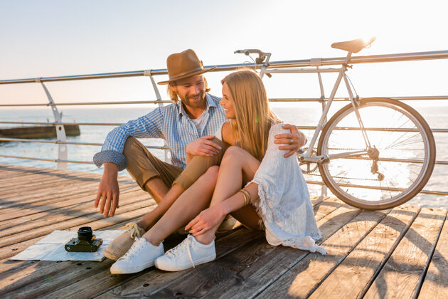 冒险迷人的快乐微笑的情侣骑着自行车在夏天的海上旅行日出约会欢呼