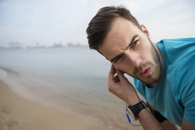 努力特写在海边慢跑的健康年轻人帅哥锻炼运动员
