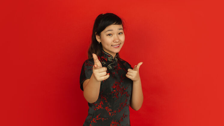 新年指着 选择 微笑2020中国新年快乐红色背景上的亚洲少女肖像穿着传统服装的女模特看起来很快乐庆祝 人类情感复制空间手女孩季节