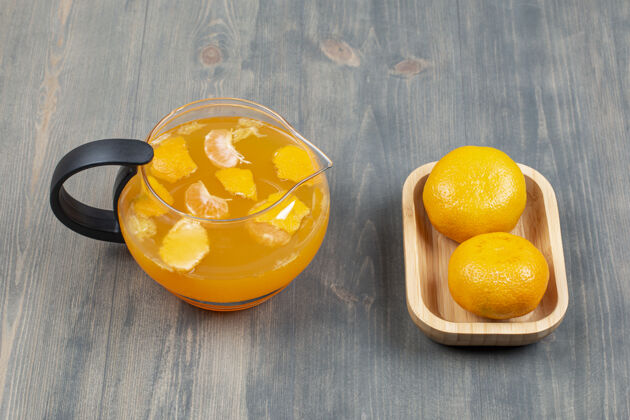 玻璃两个鲜橘子和一瓶果汁罐子多汁果汁