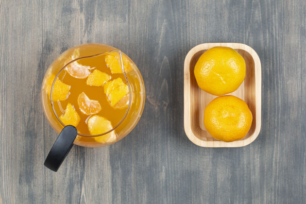 新鲜两个鲜橘子和一瓶果汁玻璃果汁自然