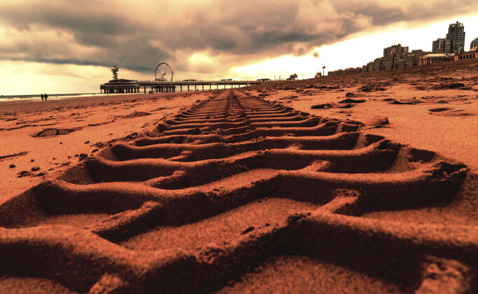 海岸特写镜头的轮胎痕迹在沙在海牙的舍维宁码头炎热赛道海岸