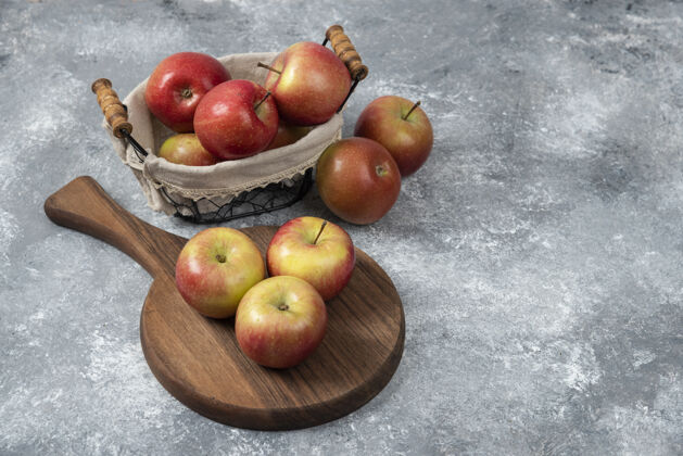 营养的把一堆新鲜成熟的苹果放在木板和篮子里完整的天然红色