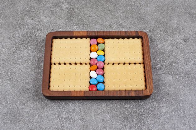 饼干饼干和五颜六色的糖果放在木盘上糖果木头美味