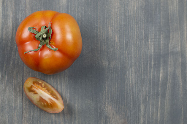 扁的一整只多汁的番茄放在木桌上扁的西红柿蔬菜