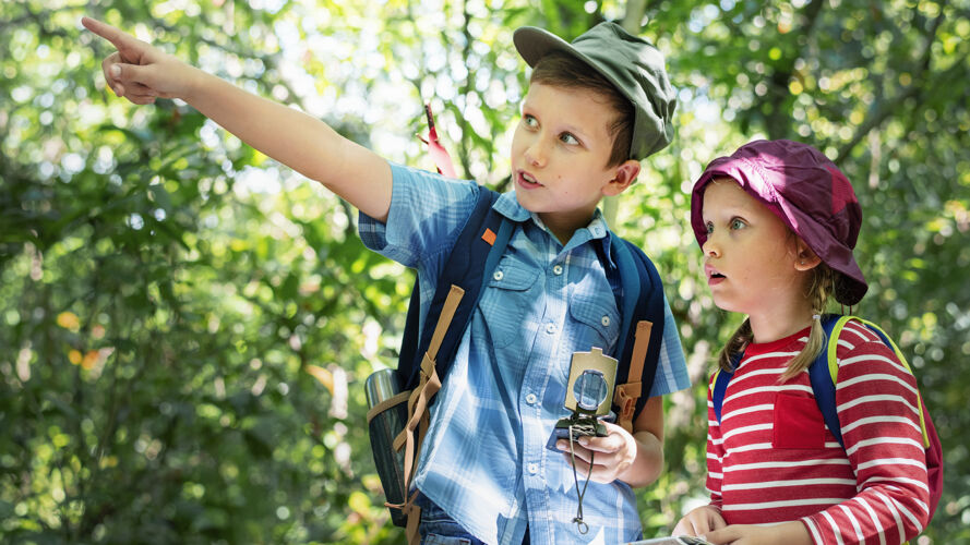 闲逛两个可爱的孩子在森林里跋涉森林指点自由
