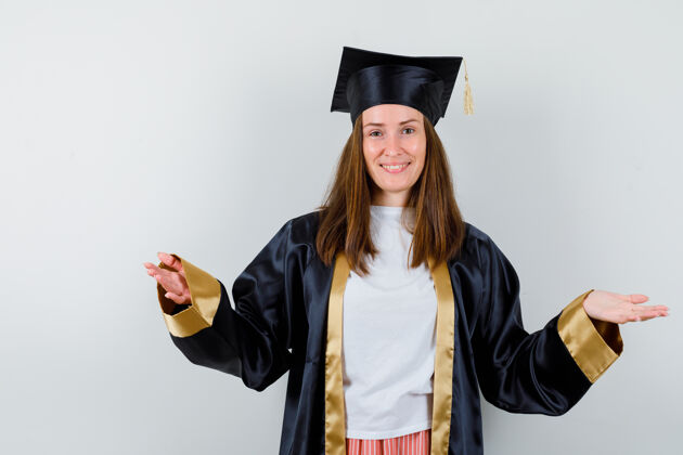 Campus女毕业生穿着学院服 两手叉开 欢快地看着前面的景色成人学校长袍