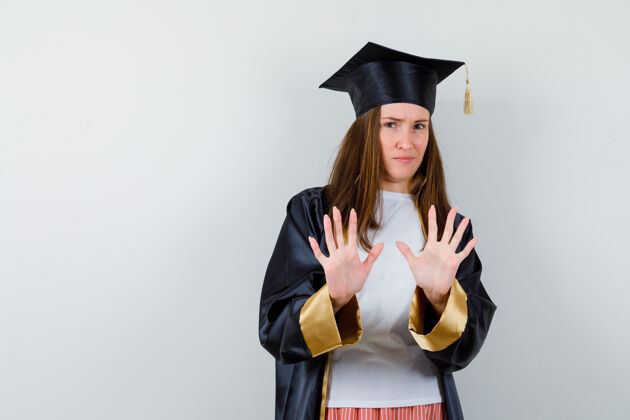 多样性毕业妇女的肖像显示停止在休闲服 制服和看起来自信的前视图姿态成就教育Cap