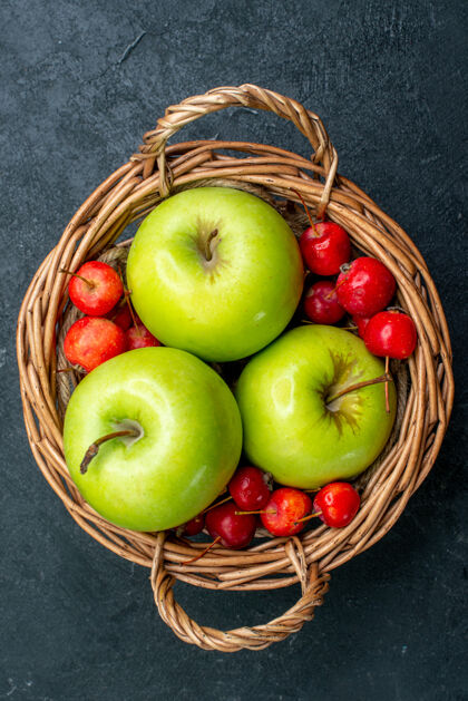 浆果顶视图篮子上有水果 苹果和甜樱桃 深色表面上有水果 浆果组成的新鲜树樱桃生的新鲜