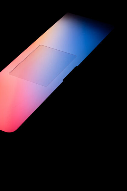 设计一个明亮的彩色光从笔记本电脑屏幕在黑暗中垂直拍摄网络概念模糊