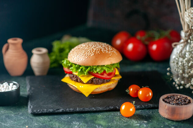 快餐前视图美味的肉汉堡包与红色西红柿在黑暗的背景生菜正餐芝士汉堡