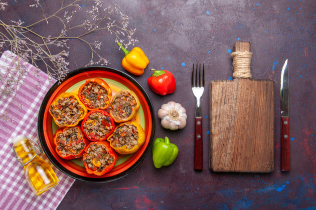 晚餐顶视图煮熟的甜椒和磨碎的肉和橄榄油在黑暗的表面一餐蔬菜食物肉多尔玛午餐磨碎的顶部