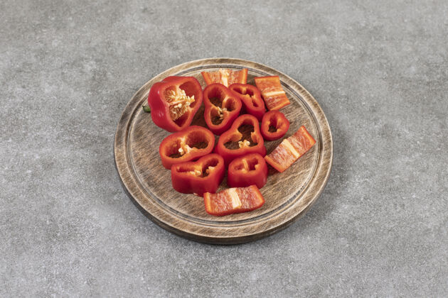 素食放在石头表面的一个装满切碎的红辣椒的木盘切片辣椒堆