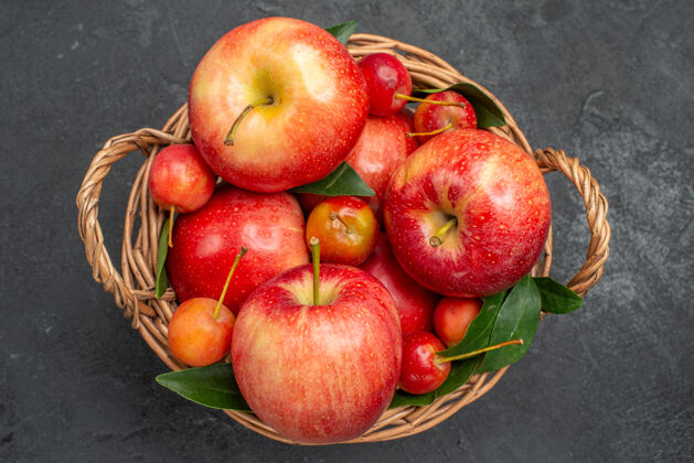 樱桃顶部特写查看水果木篮与樱桃和苹果成熟多汁有机