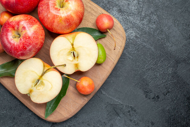 柑橘顶部特写查看苹果切菜板上的樱桃苹果柑橘类水果食物多汁切