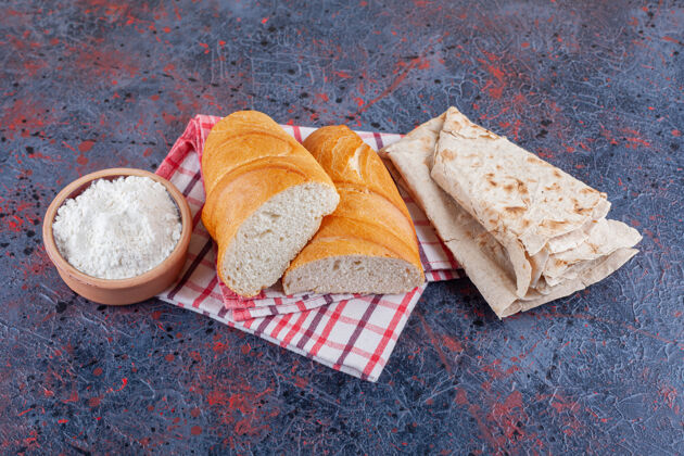 面包一碗面粉 洗碗水和切片面包放在茶巾上 蓝色的酵母美味香精
