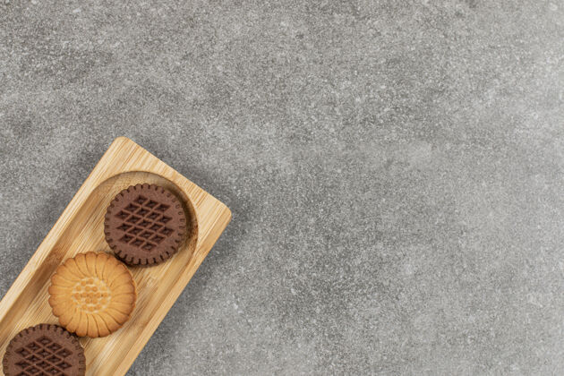 美味两种夹心饼干放在木板上饼干麦片奶油