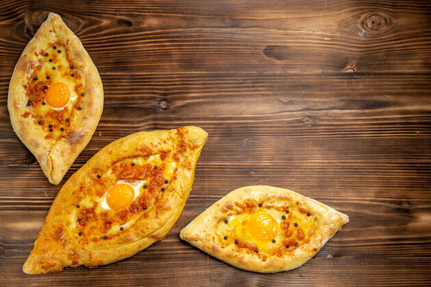 桌子顶视图烤鸡蛋面包从棕色木制桌子上的烤箱新鲜出炉面团鸡蛋面包包早餐烤箱烘焙午餐