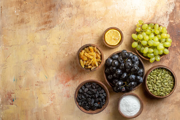 柠檬葡萄顶视图一碗串葡萄葡萄干糖柠檬南瓜子食物成熟葡萄