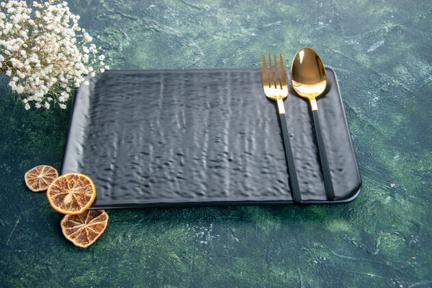 晚餐前视图黑色板与金色叉子和勺子在黑暗的背景黑色盘子深色食物