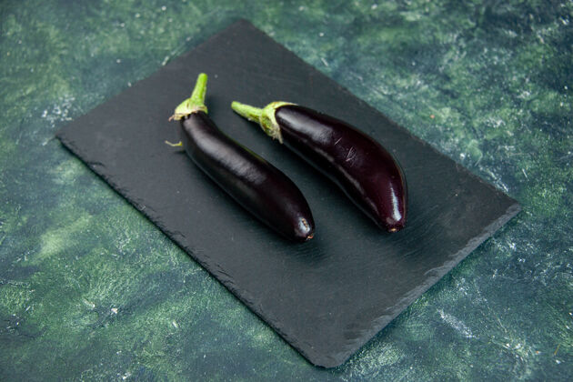 蔬菜上图：黑色背景上的黑茄子黑色茄子新鲜