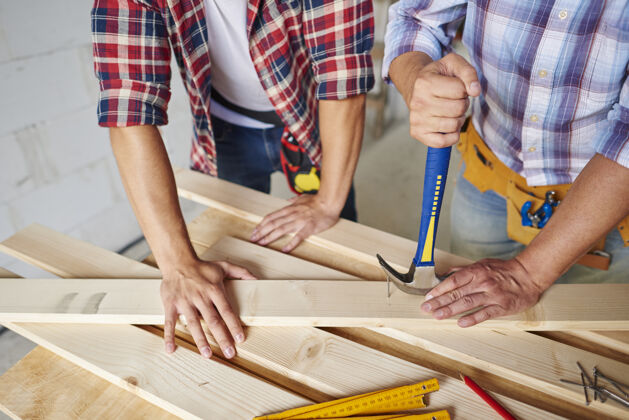 建筑木匠把钉子从木头上取下来移除工作工具仪表