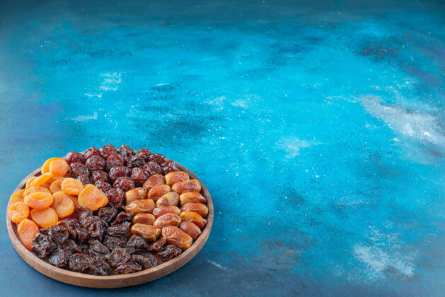 天然干果放在蓝色的木板上可口美味板