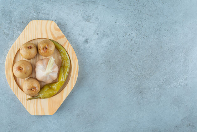美味自制发酵蔬菜放在大理石表面的木盘上可口苹果大蒜