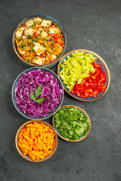 不同的蔬菜切片顶视图不同的蔬菜切片与绿色的深色餐桌上健康饮食沙拉新鲜一餐番茄