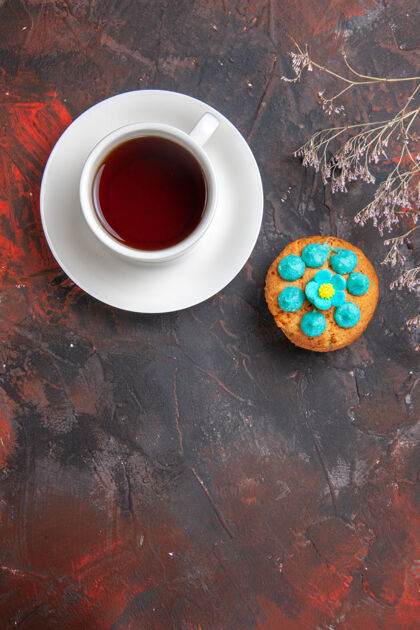 深色的在黑暗的桌子上俯瞰一杯茶和饼干饼干糖果早晨