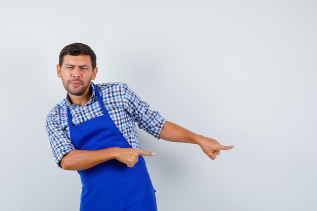 烹饪穿着蓝色围裙和衬衫的年轻男厨师男士围裙制服