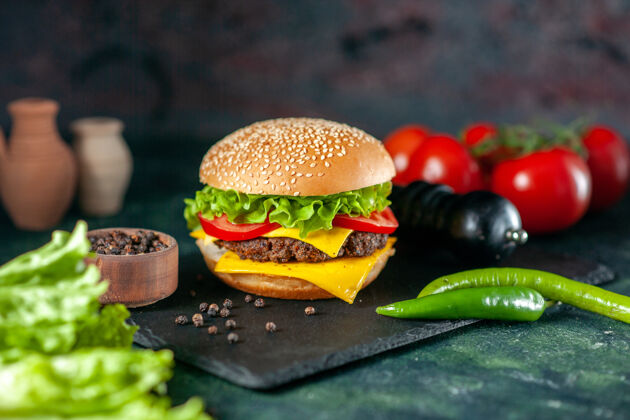 红色前视图美味的肉汉堡包与红色西红柿在黑暗的背景食物深色番茄