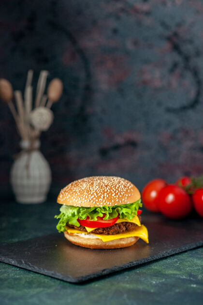 蔬菜前视图美味的肉汉堡包与红色西红柿在黑暗的背景快餐正餐小吃