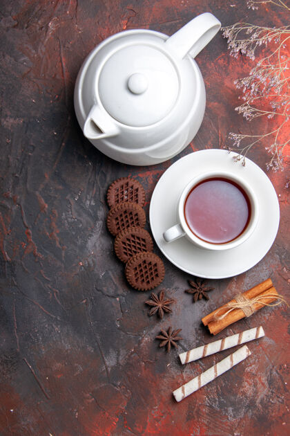 水壶俯瞰一杯茶 茶壶和饼干放在一张深色的桌子上杯子浓缩咖啡