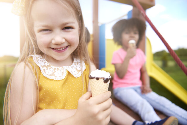 微笑特写年轻漂亮的孩子一起吃冰淇淋有趣童年快乐