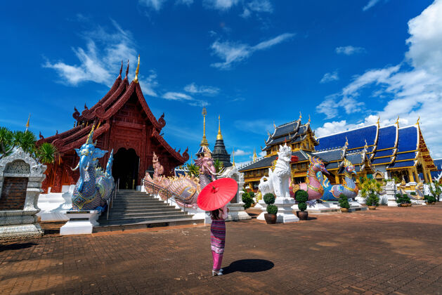 旅游在清迈的庙宇里 穿着泰国传统服饰的亚洲妇女泰国雨伞旅游