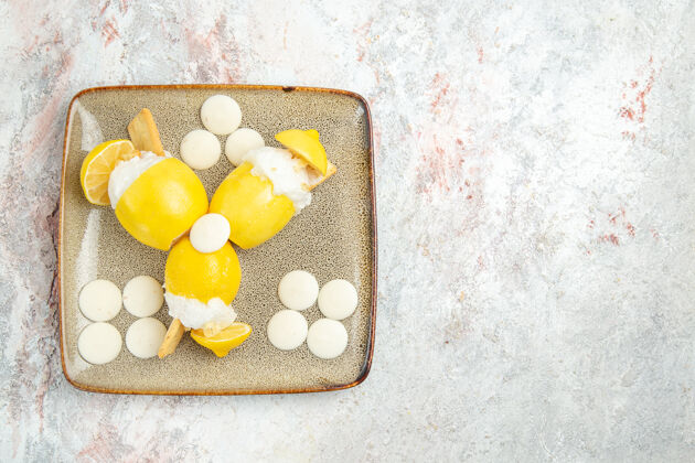 糖果俯瞰冰柠檬和白糖果在白色桌子上水果饮料鸡尾酒果汁图钉柠檬健康